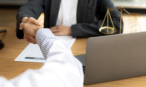 A Tempe workers’ compensation lawyer is shaking hands with a client after reaching a favorable agreement.