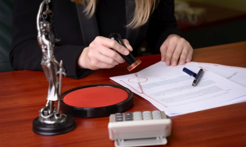 A medical malpractice lawyer sits in a Tucson law office while notarizing documents on her office desk