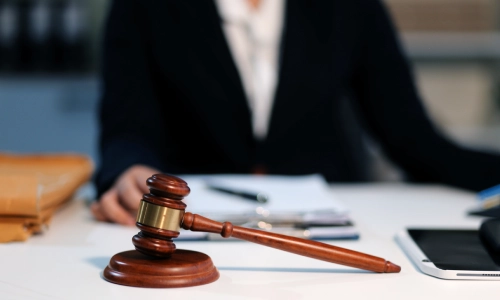A rideshare accident lawyer sits inside a Tucson law office while holding the page of a file on the office desk