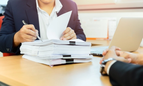 A Tucson uninsured motorist accident lawyer reviewing the drafted injury claims and discussing the details of the claims with a colleague.