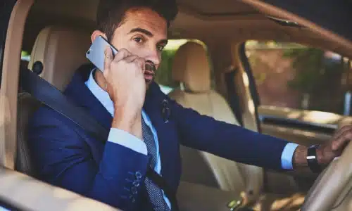 A man talking on the phone while driving a car.