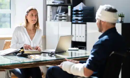 Workers' compensation accident lawyer serving the Bronx sitting in her office across from a client while discussing a case.