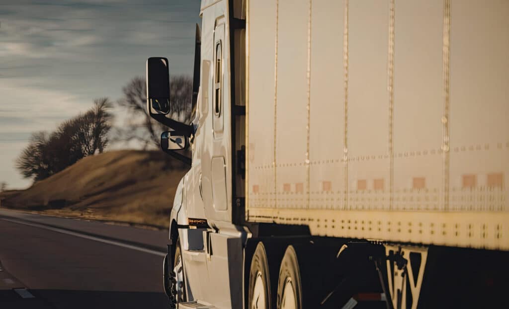 tractor trailer driving down a road